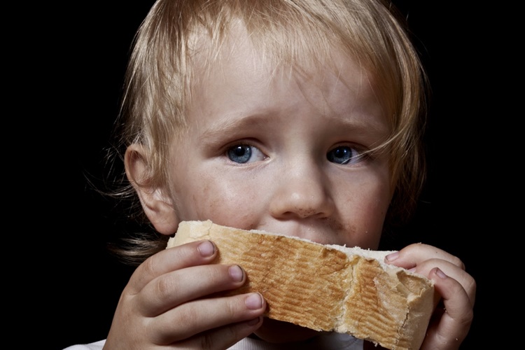 hungry child eating bread